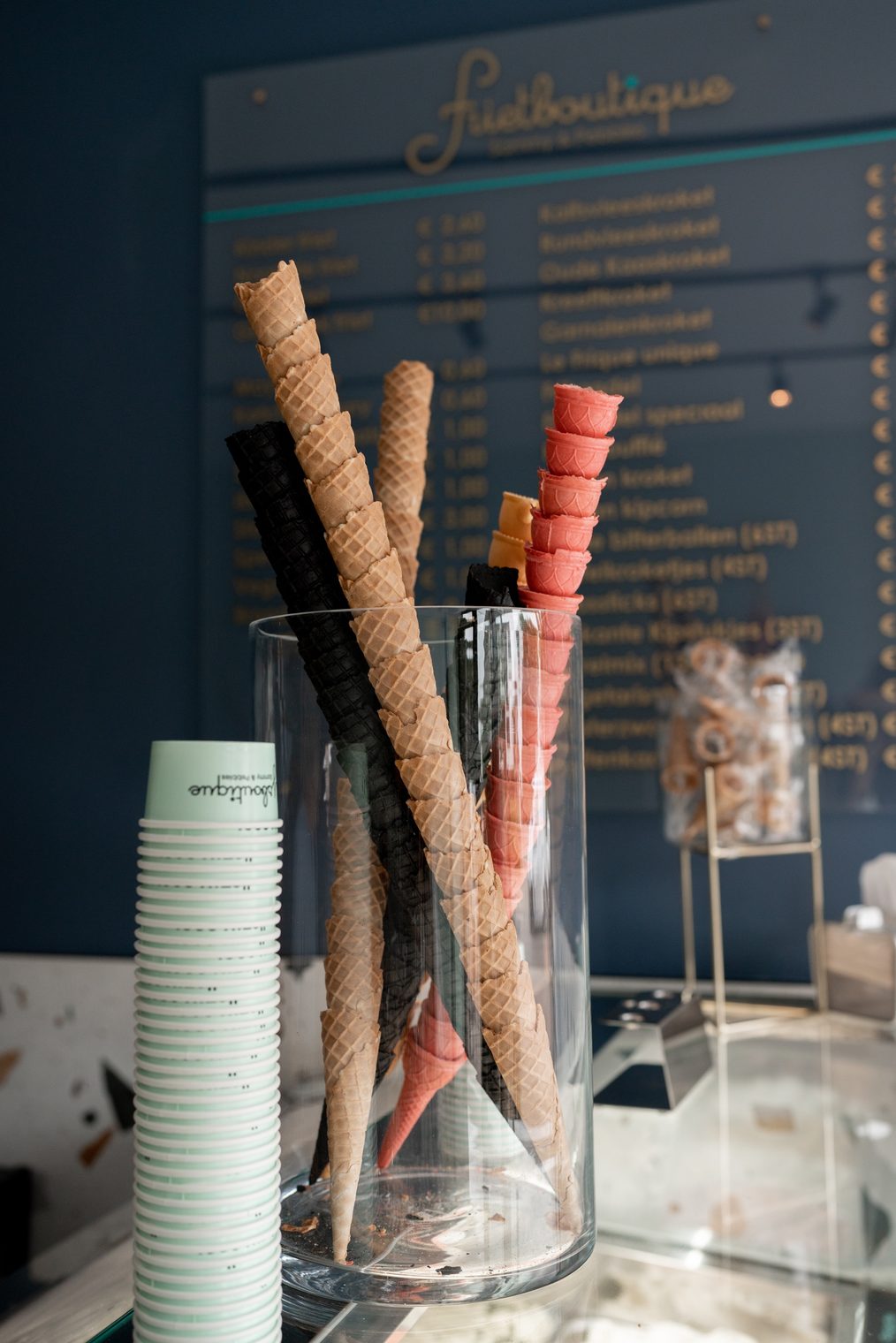 Hoorntjes en bekers bij de ijsvitrine